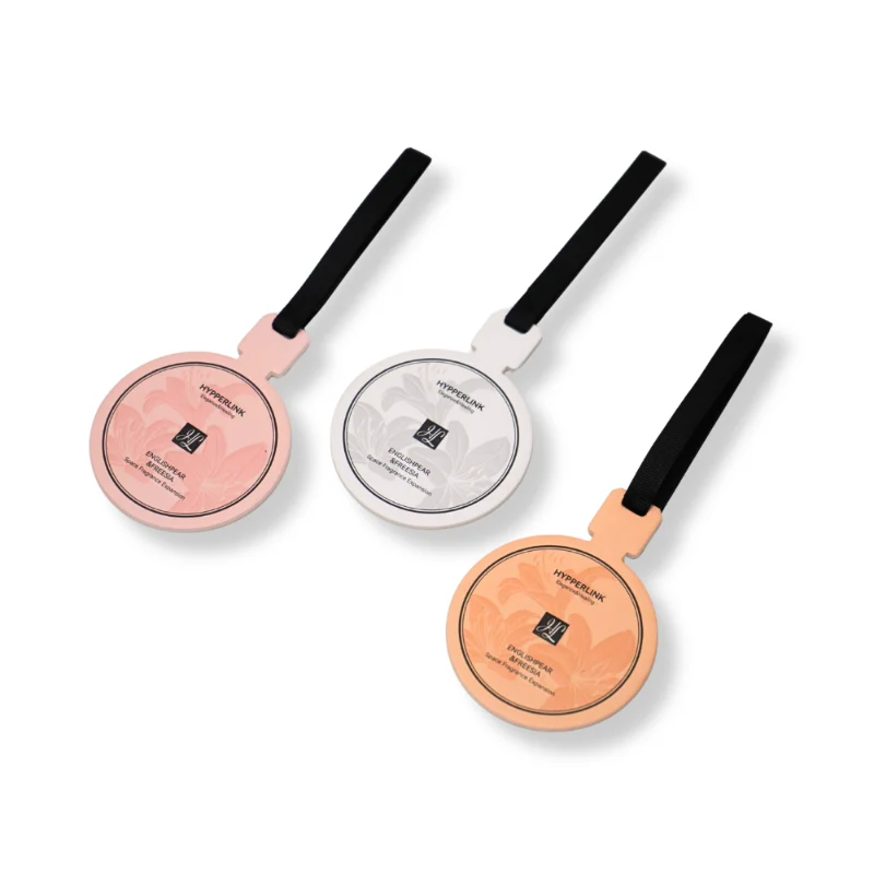 Flatlay of three English Pear and Freesia scented car air fresheners – soft pastel round fragrance cards