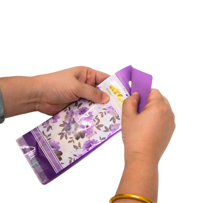 Hands opening violet scented paper air freshener